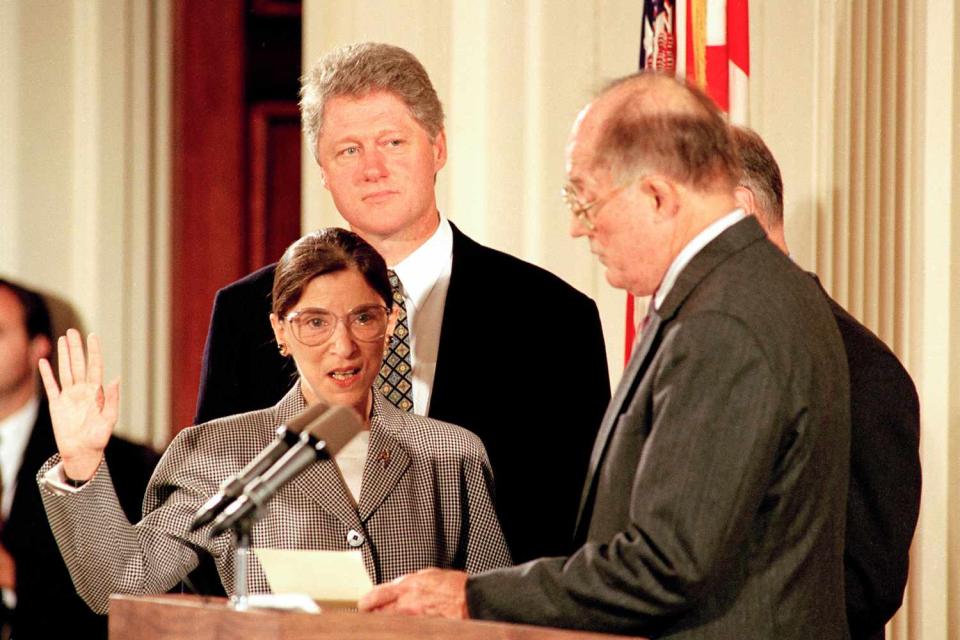<p>AP Photo/Barry Thumma</p> President Bill Clinton stands behind Ruth Bader Ginsburg as she is sworn-in to serve on the Supreme Court on Aug. 10, 1993