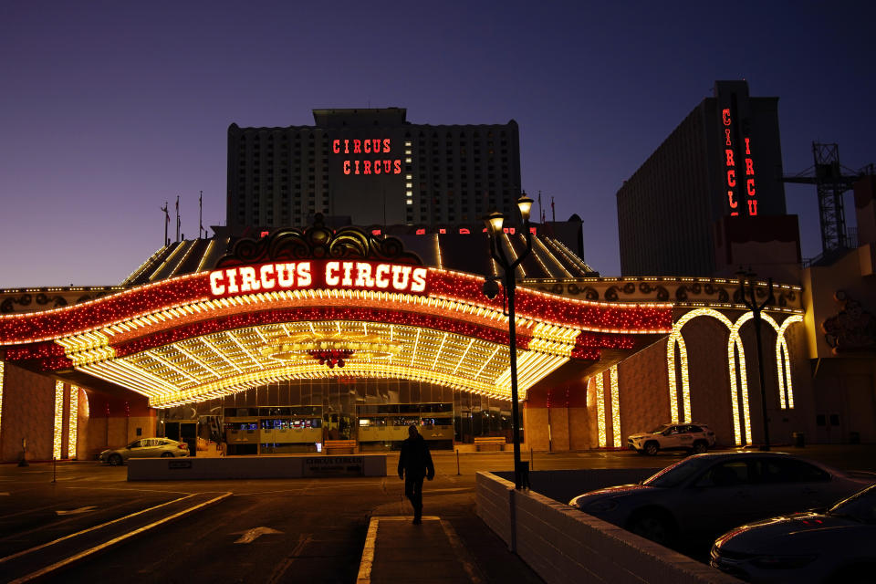 A man walks in front of the Circus Circus hotel and casino in Las Vegas, Feb. 4, 2021. The toll of the coronavirus is reshaping Las Vegas almost a year after the pandemic took hold. The tourist destination known for bright lights, big crowds, indulgent meals and headline shows is a much quieter place these days. (AP Photo/John Locher)