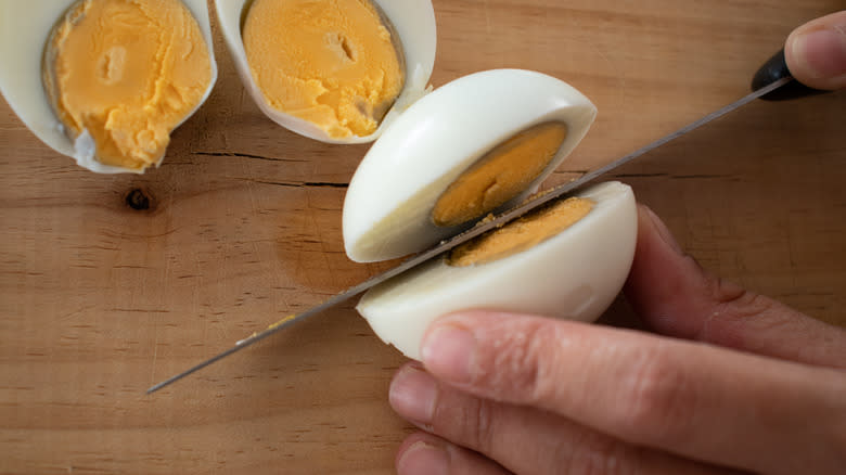 slicing boiled eggs in half