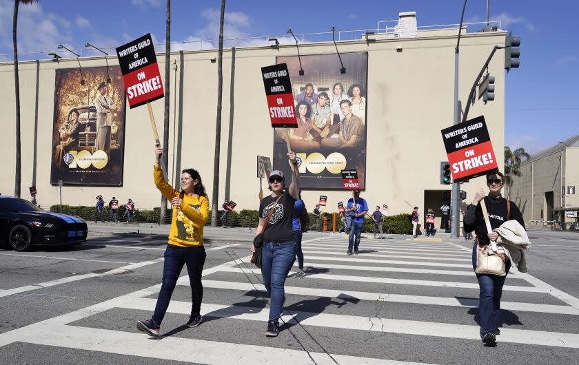 Members of The Writers Guild of America picket outside Warner Bros. Studios, Tuesday, May 2, 2023, in Burbank, Calif. The first Hollywood strike in 15 years began Tuesday as the economic pressures of the streaming era prompted unionized TV and film writers to picket for better pay outside major studios, a work stoppage that already is leading most late-night shows to air reruns. (AP Photo/Chris Pizzello)