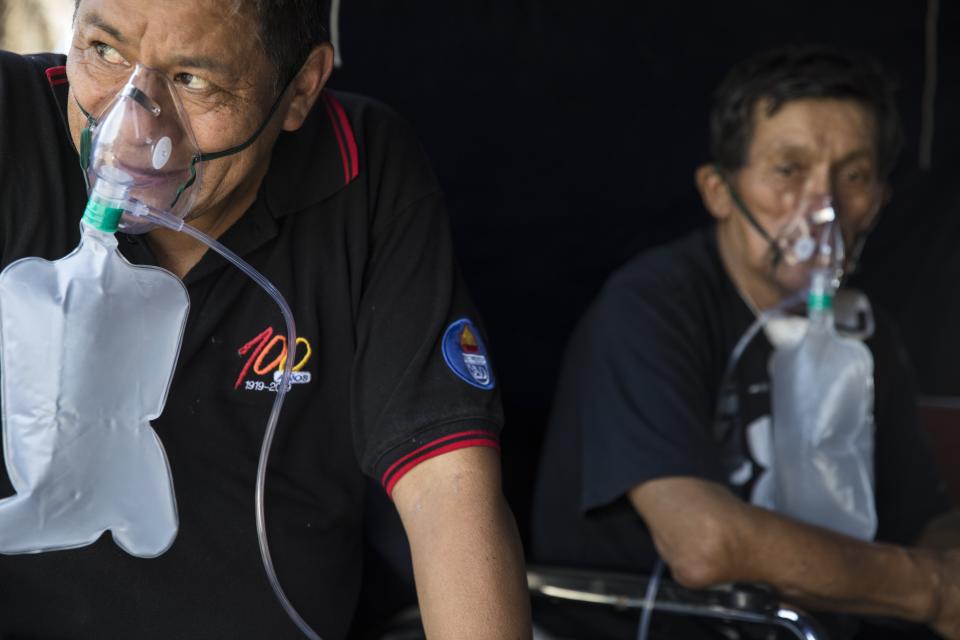 Juan Alaya, 54, supplements his oxygen in a makeshift tent set up at the 2 de Mayo Hospital to treat people who show symptoms related to the new coronavirus, in Lima, Peru, Friday, April 17, 2020. (AP Photo/Rodrigo Abd)