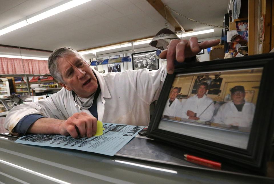 Peter Dunham has been at Jerry's Market for more than 50 years. Here, he points to a picture he had taken with his father, Gerald, who started the store in 1947, and another butcher, Al Varney, who worked there for years.