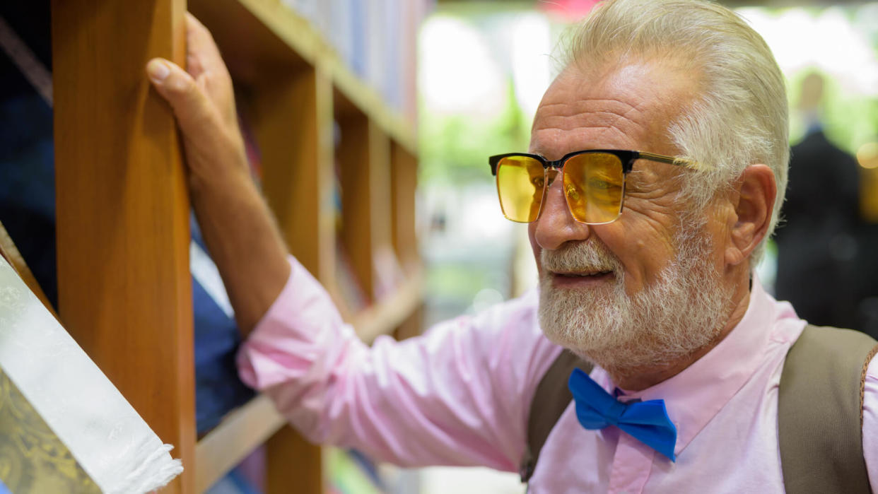 Portrait of senior handsome man wearing stylish clothes while shopping in Bangkok Thailand horizontal shot.