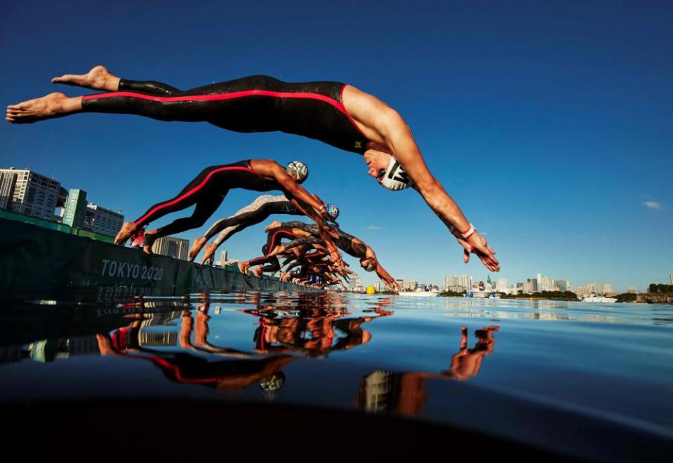 Swimmers dive in to start the men’s 10km marathon.