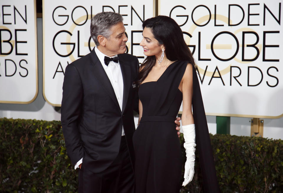 Actor George Clooney and wife, Amal Clooney, arrive at the 72nd Golden Globe Awards in Beverly Hills, California January 11, 2015.&nbsp;