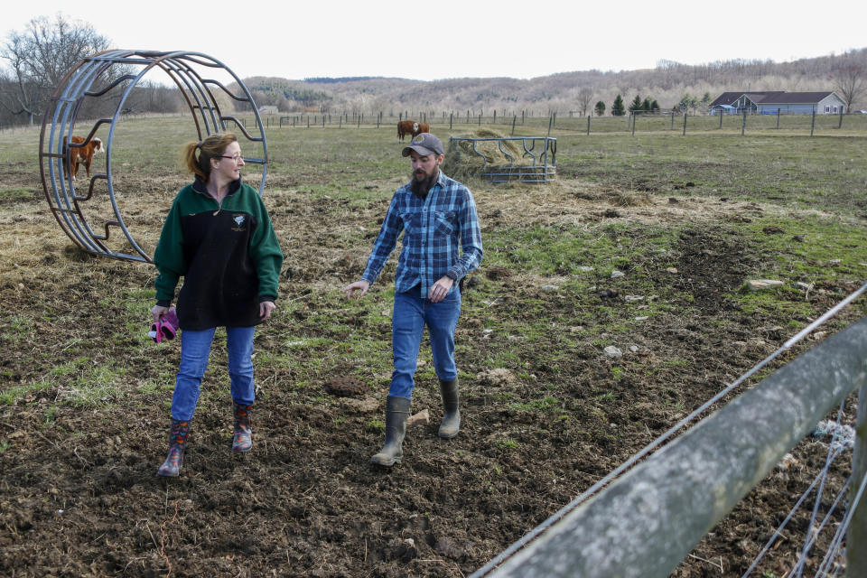 In this Friday, March 13, 2020 photo, Nic Talbott, right, walks through the pasture on his grandmothers farm with his mother, Tracy Carlton, in Lisbon, Ohio. Talbott is a plaintiff in one of four lawsuits filed in federal courts challenging a Trump administration policy barring transgender Americans from enlisting in the military. (AP Photo/Keith Srakocic)