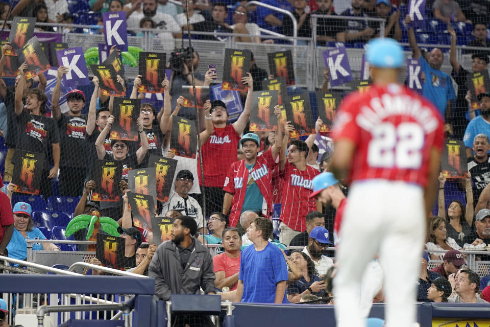 Fans hold "K" signs after Miami Marlins starting pitcher Sandy Alcantara (22) walks off the field after he struck out Washington Nationals catcher Riley Adams in the fifth inning of a baseball game, Saturday, Sept. 24, 2022, in Miami. (AP Photo/Lynne Sladky)