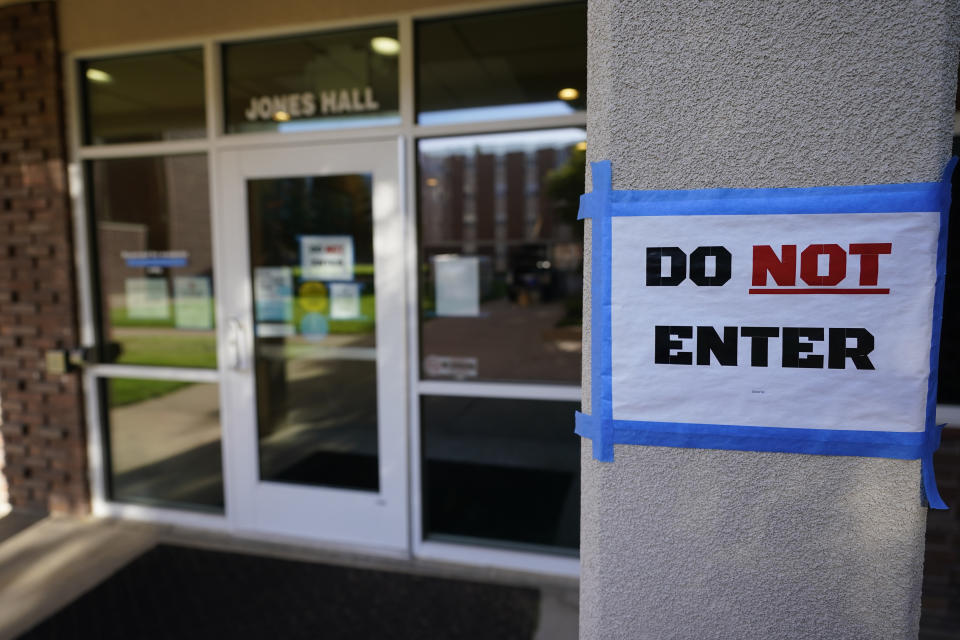 The doorway to Jones Hall is shown at Utah State University Wednesday, Sept. 2, 2020, in Logan, Utah. About 300 students quarantined to their rooms this week, but not because anyone got sick or tested positive. Instead, the warning bells came from the sewage. Colleges around the country are monitoring wastewater in hopes of stopping coronavirus outbreaks before they get out of hand. Utah State became at least the second school to quarantine hundreds of students after sewage tests detected the virus. (AP Photo/Rick Bowmer)