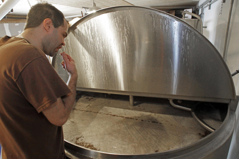 In this Wednesday, April 3, 2013 photo, brewer Shaun Hill checks a batch of beer at Hill Farmstead Brewery in Greensboro, Vt. Vermonters are buzzing about beer, and with good reason. The craft brew world has noticed that the small New England state better known for its cheeses and maple syrup also happens to make killer beer. In fact, one brewery, Hill Farmstead Brewery, has been rated the world's best brewer on a popular international consumer review website called RateBeer.com. (AP Photo/Toby Talbot)