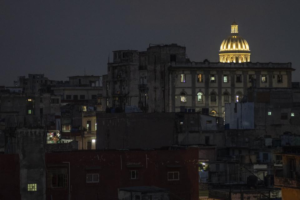 The Capitol dome is illuminated amid residential buildings in downtown Havana, Cuba, late Monday, Oct. 9, 2023. Cuba's housing crisis is one of the most pressing challenges facing the island, where a humid climate, the passage of cyclones and hurricanes, poor maintenance of old buildings and a low completion rate of new ones are usually among the top complaints among residents. (AP Photo/Ramon Espinosa)