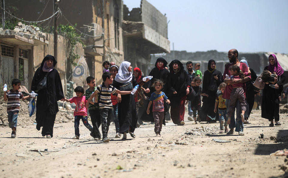 <p>Civilians flee from the Old City of Mosul as Iraqi forces advance on June 20, 2017, during the ongoing offensive by Iraqi forces to retake the last district still held by the Islamic State (IS) group. (Photo: Ahmad al-Rubaye/AFP/Getty Images) </p>