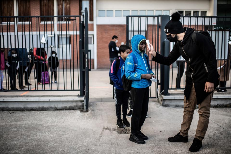 Students have their temperatures checked before entering the Saint-Exupery school in the Paris' suburb of La Courneuve on May 14. (Photo: MARTIN BUREAU via Getty Images)