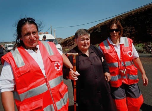 Red Cross members help a neighbor of the small town of La Restinga to walk towards a soccer field as a precaution against another possible undersea volcanic eruption, on October 11. Two new volcanic eruptions were confirmed on Wednesday near Spain's El Hierro island in the Canaries, where 500 people spent another night outside their homes after being evacuated as a precautionary measure