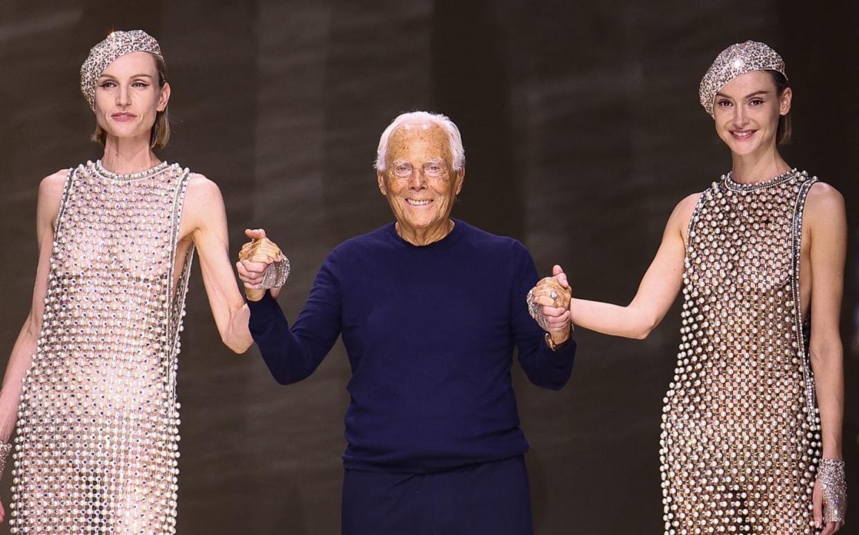 Giorgio Armani with two models