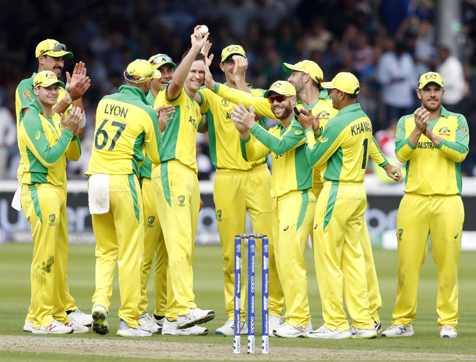 Australia's Jason Behrendorff, centre, holds up the ball as he celebrates with teammates after taking the wicket of England's Jofra Archer during the Cricket World Cup match between England and Australia at Lord's cricket ground in London, Tuesday, June 25, 2019. (AP Photo/Alastair Grant)