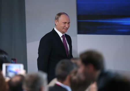 Russian President Vladimir Putin walks in to attend his annual end-of-year news conference in Moscow, December 18, 2014. REUTERS/Maxim Zmeyev