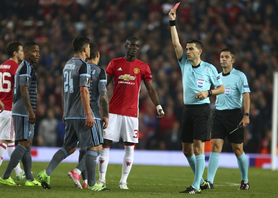 <p>Romanian referee Ovidiu Hategan (R) shows a red card to Manchester United’s Eric Bailly (C), after a clash with Celta Vigo players at Old Trafford stadium in Manchester, north-west England, on May 11, 2017 </p>