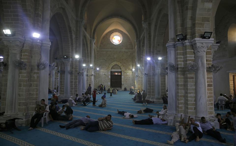 <p>Men reads verses of the Quran, Islam’s holy book, during Laylat al-Qadr prayers during Ramadan at al-)mari mosque in Gaza City, May 29, 2017. (AP Photo/Hatem Moussa) </p>