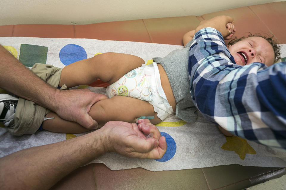 FILE - In this Jan. 29, 2015, file photo, pediatrician Dr. Charles Goodman vaccinates 1 year-old Cameron Fierro with the measles-mumps-rubella vaccine, or MMR vaccine at his practice in Northridge, Calif. Gov. Gavin Newsom says he has concerns about enacting tougher rules that limit parents from choosing whether to vaccinate their schoolchildren. The measure would give state public health officials instead of local doctors the authority to decide which children can skip their shots before attending school. Newsom said Saturday, June 1, 2019, that as a parent, he wouldn't want a bureaucrat to make personal decision for his family. (AP Photo/Damian Dovarganes, File)