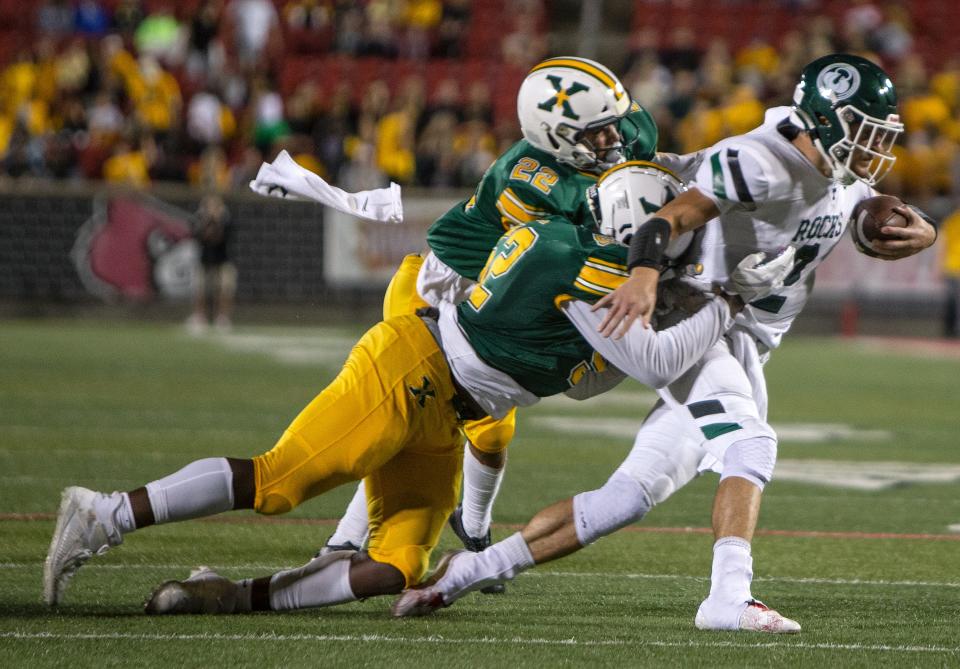 Trinity quarterback Andrew Allen is drug down by St. Xavier defenders drug their annual game at Louisville's Cardinal Stadium. Sept. 23, 2022