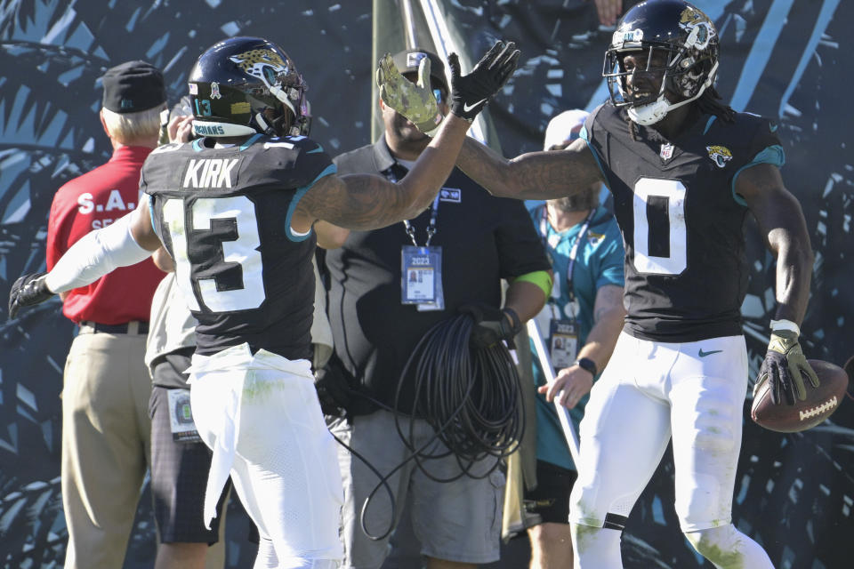 Jacksonville Jaguars' Christian Kirk (13) congratulates wide receiver Calvin Ridley (0) after a touchdown during the second half of an NFL football game against the Tennessee Titans, Sunday, Nov. 19, 2023, in Jacksonville, Fla. (AP Photo/Phelan M. Ebenhack)