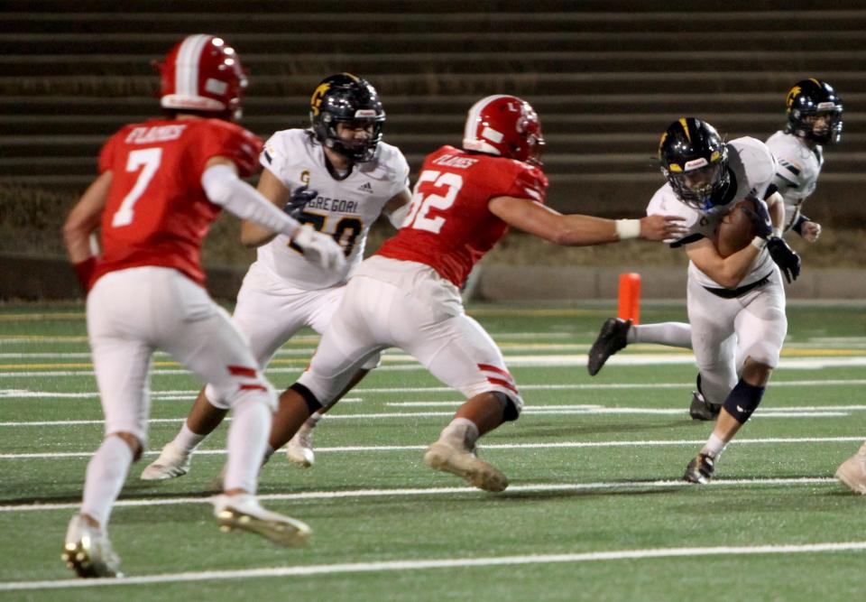 Gregori's Michael Marsden runs the ball Friday night as Lodi High's Nathan Bishop goes to stop him down at the Grape Bowl in Lodi on Friday, Sept. 23, 2022.