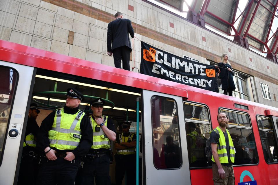 Climate change protestors stand atop a DLR train at Canary wharf station (AFP/Getty Images)