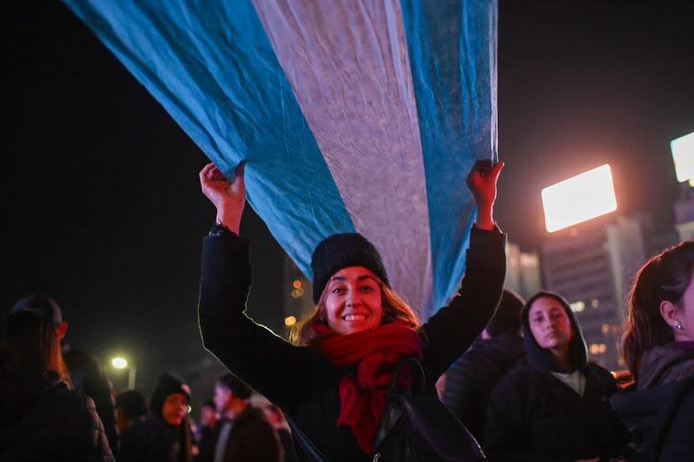 Una mujer levanta una bandera durante los festejos en el Obelisco