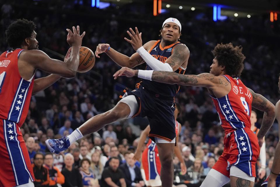 Philadelphia 76ers' Kelly Oubre Jr., right, knocks the ball away from New York Knicks' Miles McBride, center, as 76ers' Joel Embiid, left, defends during the second half of Game 2 in an NBA basketball first-round playoff series Monday, April 22, 2024, in New York. (AP Photo/Frank Franklin II)