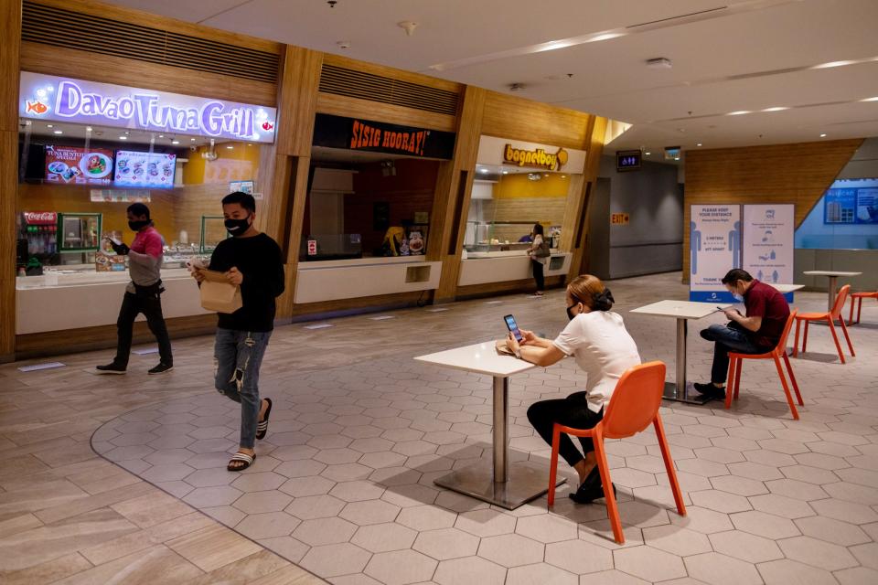 Diners wait for their orders at a food court where only one customer per table is allowed, as the Philippine government allows dining-in following months of restrictions due to the coronavirus disease (COVID-19) outbreak, in Mandaluyong City, Metro Manila, Philippines, June 16, 2020. REUTERS/Eloisa Lopez