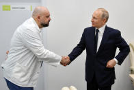 FILE - In this Monday, March 23, 2020 file photo, Russian President Vladimir Putin, right, shakes hands with the hospital's chief Denis Protsenko during his visit to the hospital for coronavirus patients in Kommunarka, outside Moscow, Russia. From the U.S. president to the British prime minister's top aide and far beyond, leading officials around the world are refusing to wear masks or breaking confinement rules meant to protect their populations from the coronavirus and slow the pandemic. While some are punished when they're caught, or publicly repent, others shrug off the violations as if the rules don't apply to them. (Alexei Druzhinin, Sputnik, Kremlin Pool Photo via AP, File)