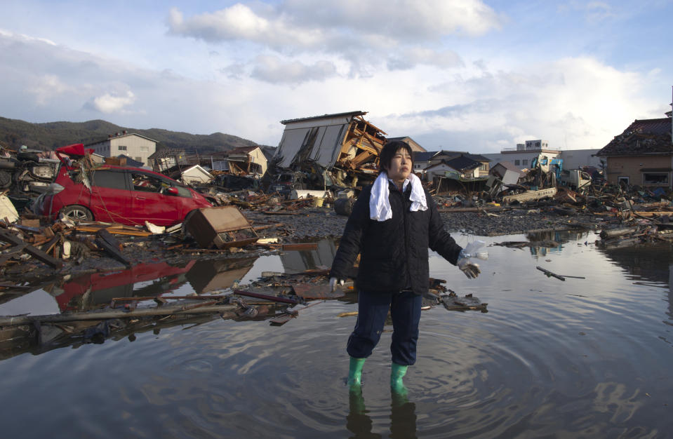 KESENNUMA, JAPAN - MARCH 16: Chieko Chiba walks through the rubble after going to see her destroyed home March 16, 2011 in Kesennuma, Miyagi province, Japan. The 9.0 magnitude strong earthquake struck offshore on March 11 at 2:46pm local time, triggering a tsunami wave of up to ten metres which engulfed large parts of north-eastern Japan. As the death toll continues to rise, the country is also struggling to contain a potential nuclear meltdown after the nuclear plant was seriously damaged from the quake. (Photo by Paula Bronstein/Getty Images)