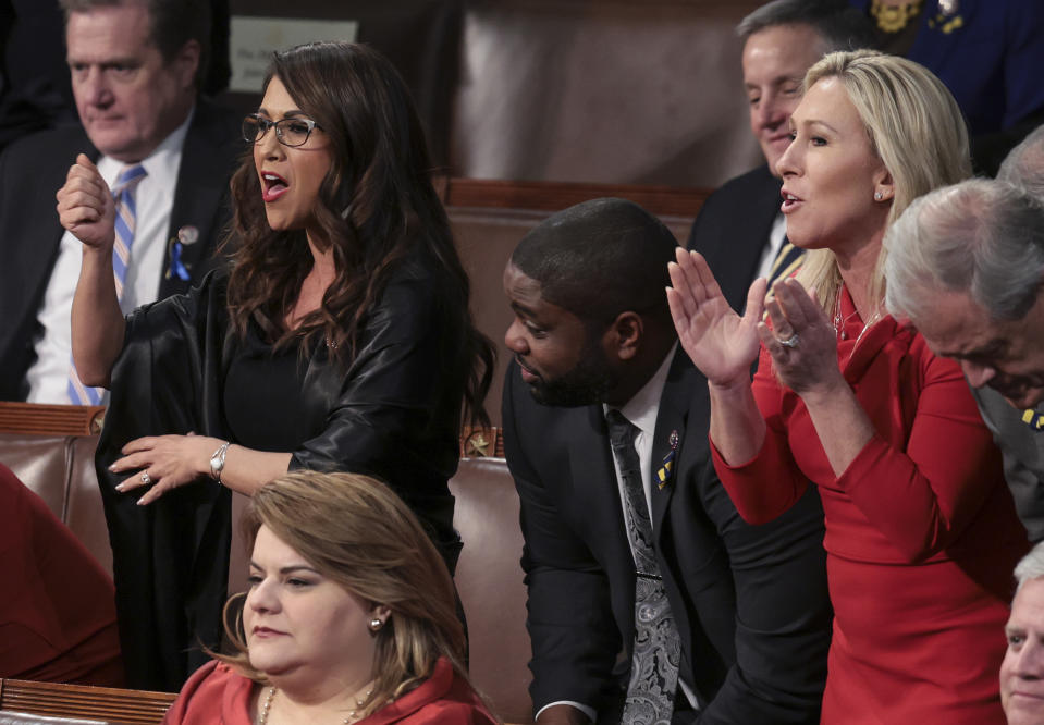 Rep. Lauren Boebert, R-Colo., left, Rep. Byron Donalds, R-Fla., and Rep. Marjorie Taylor Greene, R-Ga., stand with fellow lawmakers as they listen to President Joe Biden deliver his State of the Union address to a joint session of Congress at the Capitol, Tuesday, March 1, 2022, in Washington. (Win McNamee, Pool via AP)
