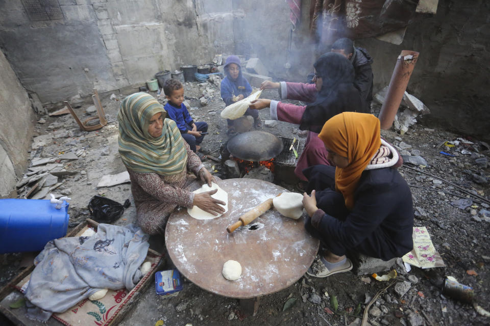 Palestinians bake bread by their destroyed homes in Kuza' a Gaza Strip during the temporary ceasefire between Hamas and Israel on Wednesday, Nov. 29, 2023. AP Photo/Hatem Ali)