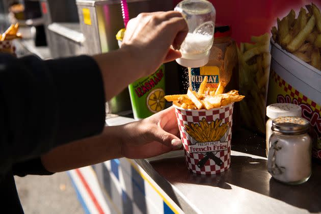 A festivalgoer puts salt on their fries. (Photo: Damon Dahlen/HuffPost)