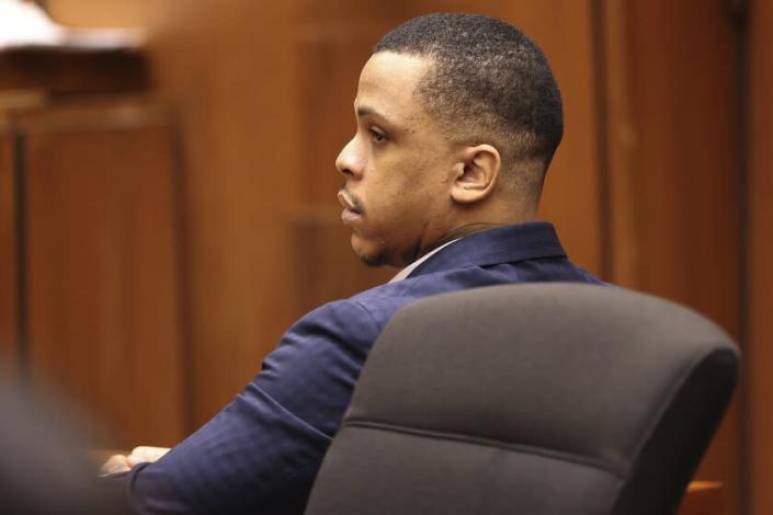 Defendant Eric Holder listens to opening statements in his murder trial in Los Angeles.