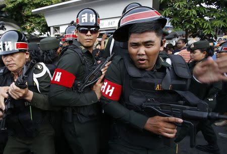 A soldier (R) reacts after he was hit by a bottle of water during a scuffle with protesters against military rule at Victory Monument in Bangkok May 28, 2014. REUTERS/Erik De Castro