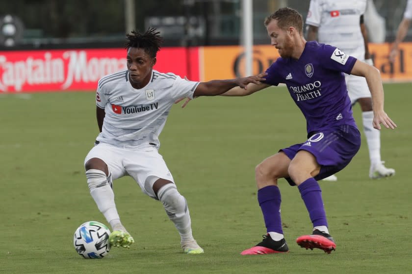 Orlando City midfielder Oriol Rosell, right, and Los Angeles FC forward Latif Blessing, left, tangle during the first half of an MLS soccer match, Friday, July 31, 2020, in Orlando, Fla. (AP Photo/John Raoux)