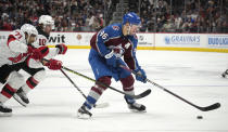 Colorado Avalanche right wing Mikko Rantanen (96) drives past New Jersey Devils defenseman Jonas Siegenthaler, front left, and right wing Alexander Holtz in the third period of an NHL hockey game on Tuesday, Nov. 7, 2023, in Denver. (AP Photo/David Zalubowski)