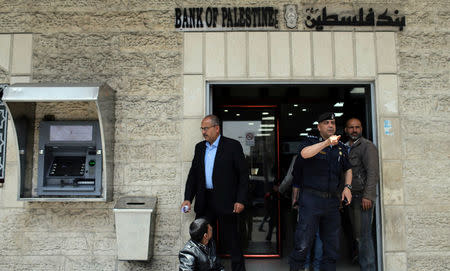 A Palestinian Hamas policeman gestures at a bank in Gaza City April 12, 2018. REUTERS/Ibraheem Abu Mustafa