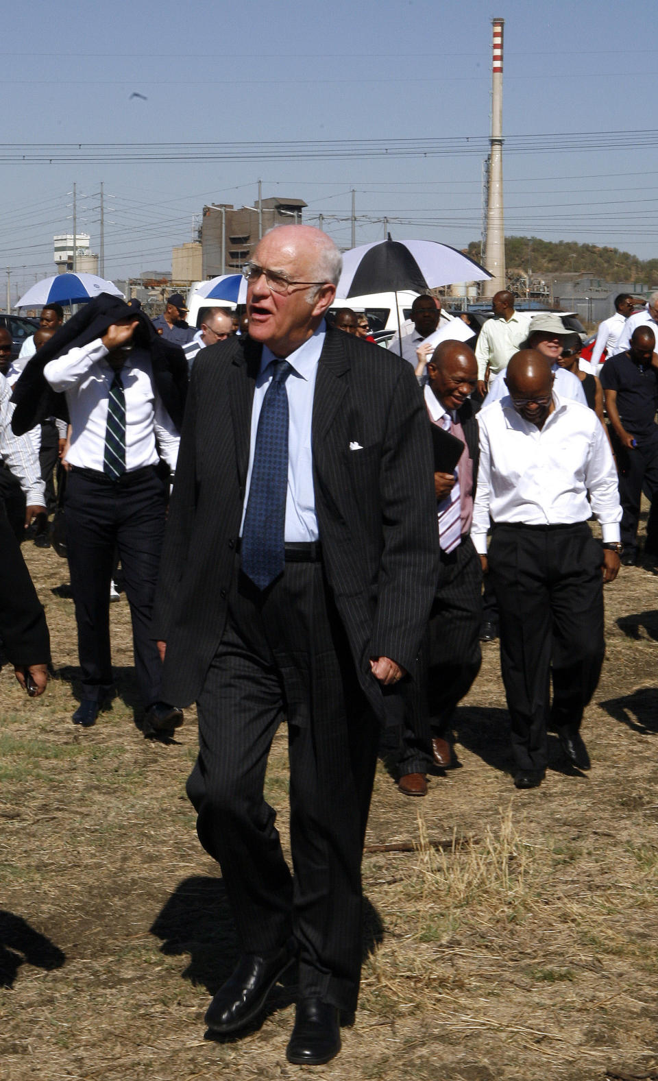 Retired judge Ian Farlam and his team as they inspect the area where the bodies of mine workers were found after the shootings at Lonmin's platinum mine in Marikana near Rustenburg, South Africa, Monday, Oct. 1, 2012. An official inquiry into the killings of dozens of people near a South African platinum mine began Monday even as labor unrest continued with workers at other mines as well as truck drivers continuing protests over pay. (AP Photo/Themba Hadebe)