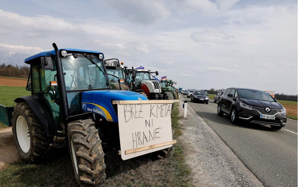 A placard reading 'no farmers no food' is displayed on a tractor in Kranj, Slovenia - Shutterstock