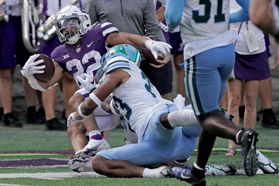 Kansas State running back Deuce Vaughn (22) is tackled by Tulane safety Lummie Young IV, front, during the first half of an NCAA college football game Saturday, Sept. 17, 2022, in Manhattan, Kan. (AP Photo/Charlie Riedel)