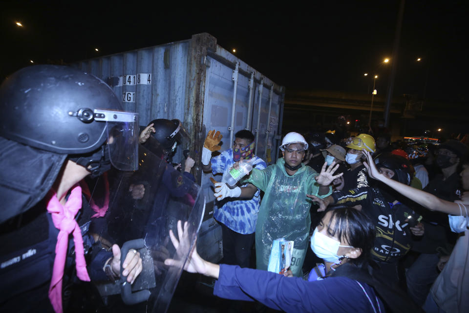 Anti-government protesters clash with riot police, during a protest in Bangkok, Thailand, Sunday, Feb. 28 , 2021. The anti-government protesters marched to a military house where Prime Minister Prayuth Chan-ocha lives to call for the monarchy reform and the military removal from the politics. (AP Photo)