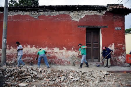 Municipal workers remove debris from a damaged house after an earthquake in Antigua, Guatemala June 22, 2017. REUTERS/Luis Echeverria