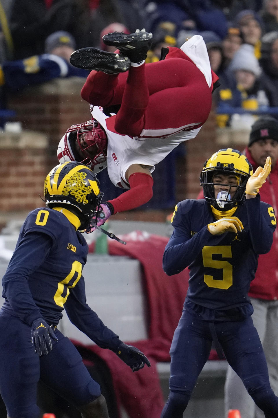 Nebraska wide receiver Alante Brown (4) is upended by Michigan defensive back Mike Sainristil (0) as DJ Turner (5) looks on in the first half of an NCAA college football game in Ann Arbor, Mich., Saturday, Nov. 12, 2022. (AP Photo/Paul Sancya)