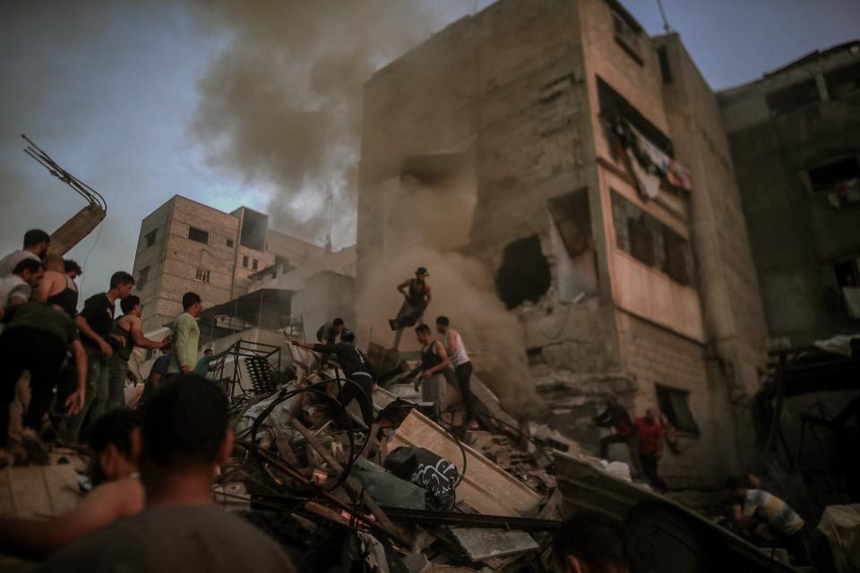 Civilians and Palestinian rescue teams, facing a severe lack of facilities, are determinedly sifting through the rubble of buildings destroyed during Israeli air raids in the southern Gaza Strip, particularly in Khan Yunis, Gaza (Middle East Images/AFP via Getty)