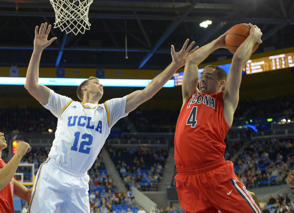 Arizona guard T.J. McConnell, right, grabs a rebound away from UCLA forward David Wear during the first half of an NCAA college basketball game on Thursday, Jan. 9, 2014, in Los Angeles. (AP Photo/Mark J. Terrill)