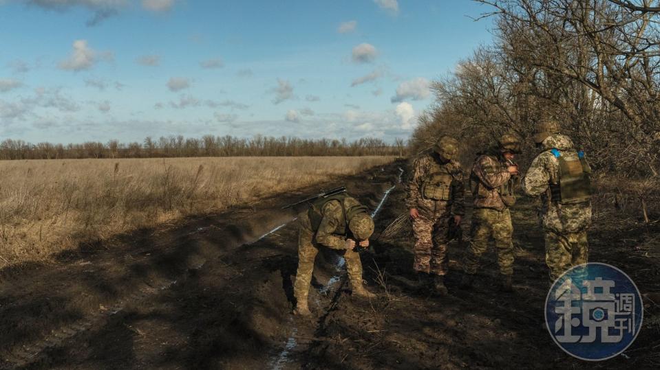 4名炮兵在發射M777榴彈炮後抽菸、休息片刻。這個場景顯示出人力減少的影響，通常需要8名士兵才能操作這種口徑的大炮。短暫的喘息凸顯出有限的人員在管理威力如此強大的火炮操作時，所面臨到的挑戰。