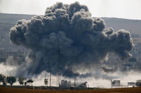 An explosion following an air-strike is seen in the Syrian town of Kobani from near the Mursitpinar border crossing on the Turkish-Syrian border in the southeastern town of Suruc in Sanliurfa province October 28, 2014 REUTERS/Yannis Behrakis